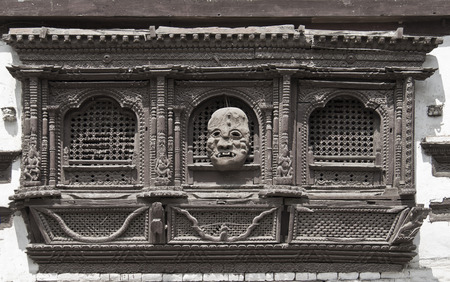 very old carved window and mask on it in Kathmandu, Nepalのeditorial素材