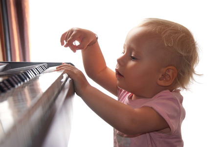 little blonde girl playing pianoの写真素材