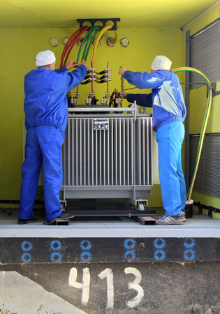 electricians working at high voltage power transformerの写真素材