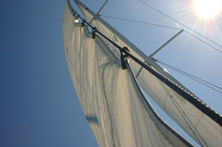 Sail of a sailing boat against blue skyの写真素材