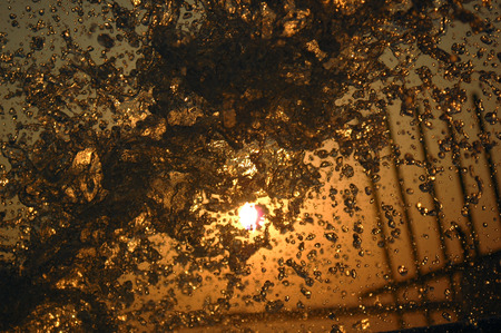 strong water torrent in front of sunの写真素材