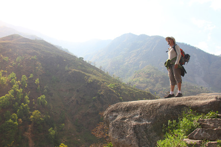 hiker stand on the hill and enjoys the view