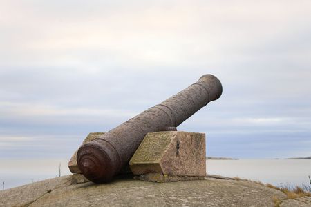 An old rusty iron cannon on Finnish coast aimed at sea.の写真素材