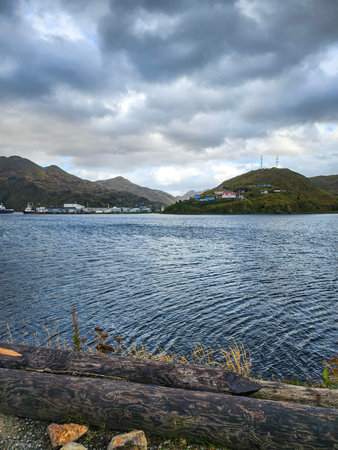 Coastal Alaska view with quiet bay, village on hillside, and dramatic sky over Unalaska in the...