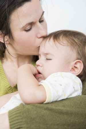 Mother kissing her ill babyの写真素材