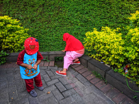 batu, indonesia - 3 april, 2019 : two small brothers and sisters playing in the park near jatim park 2のeditorial素材