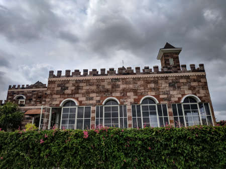 malang, indonesia -14 february, 2021 : a fence with green plants against the background of an office building with a European architectural styleのeditorial素材
