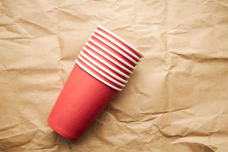 stack of disposable red paper cups on paper background. eco friendly concept. copyspace. look from above. background backdropの写真素材