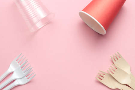 eco-friendly and plastic kitchenware template or frame. wooden spoons and forks at pink coral backgroundの写真素材