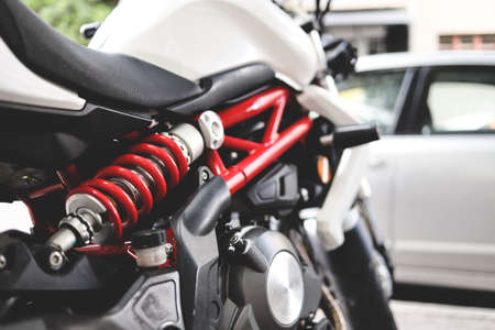 close up black and white motorcycle at city space with red colored shock absorber. selective focus. city bikeの写真素材