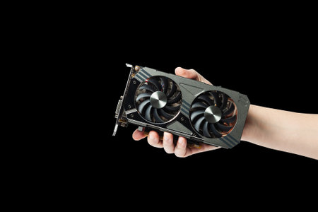 man hold graphic gpu video adapter isolated on a black background. hardware for processing with...