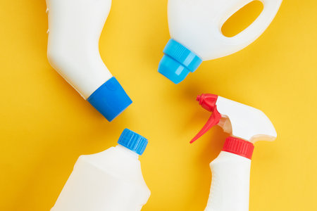 blank chemicals bottles on a bright yellow background. copy space. cleaning and washing conceptの写真素材