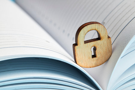 business privacy concept. wooden padlock on a opened notepad. copy spaceの写真素材