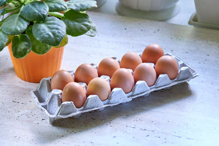 stack of hen eggs at cardon container on a kitchen table. healthy eating lifestyle concept