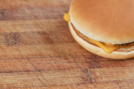 thin cheeseburger or hamburger on a wooden board with diagonal lines background.selective focus. copy spaceの写真素材