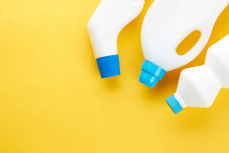 blank chemicals bottles on a bright yellow background. copy space. cleaning and washing concept