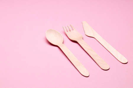 eco-friendly disposable utensills concept. bamboo or wooden cutlery over pink color backgroundの写真素材