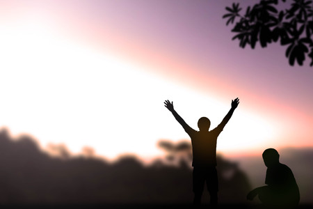 Silhouette one winner man and one lost man on Beautiful evening sunset above the mountain in Thailandの写真素材