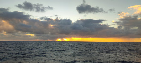 A vast expanse of water accompanied by a cloudy sky overheadの写真素材