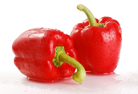 Two wet red peppers isolated on whiteの写真素材