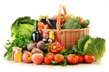 Composition with raw vegetables and wicker basket isolated on whiteの写真素材