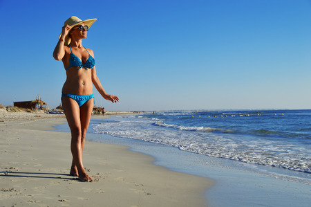 Woman standing on the mediterranean beach on hot summer day.の写真素材