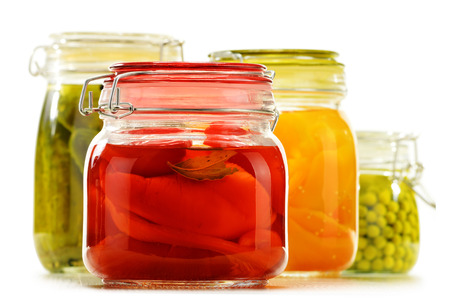 Jars with pickled vegetables and fruity compotes isolated on white background. Preserved foodの写真素材