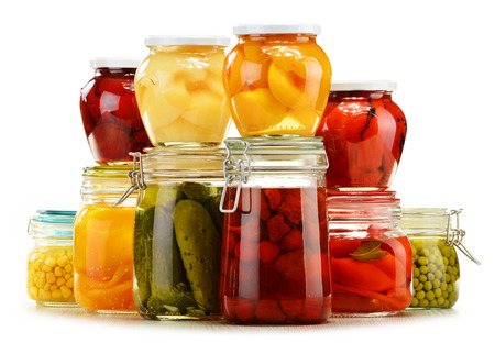 Jars with pickled vegetables and fruity compotes isolated on white background. Preserved foodの写真素材