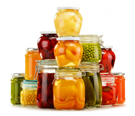 Jars with pickled vegetables, fruity compotes and jams isolated on white background. Preserved foodの写真素材