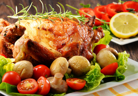 Roasted chicken with tomatoes and mushrooms.の写真素材