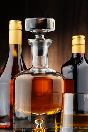 Composition with bottles of assorted alcoholic beverages and glass of whiskyのeditorial素材