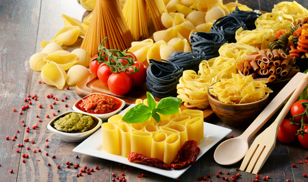 Composition with different sorts of pasta on kitchen table.の写真素材