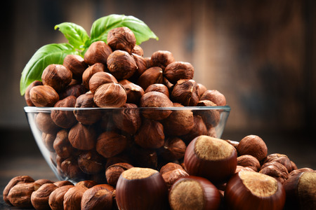 Bowl with hazelnuts on wooden table. Delicacies