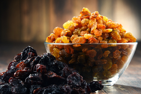 Composition with bowl of raisins on wooden table.の写真素材