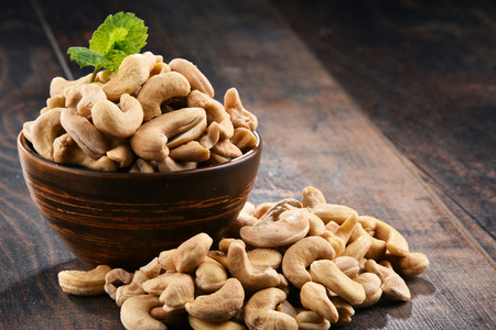 Bowl with cashew nuts on wooden table. Delicaciesの写真素材