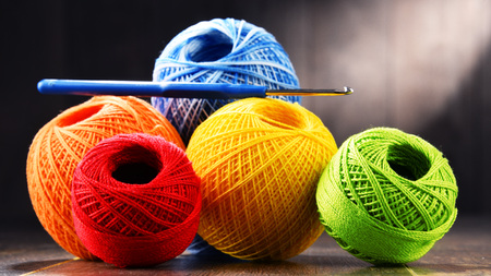 Colorful yarn for crocheting and hook on wooden table.の写真素材