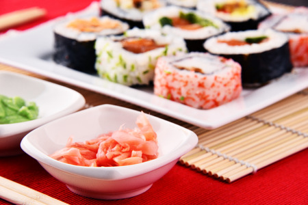 Composition with assorted sushi rolls and bowls of spicesの写真素材