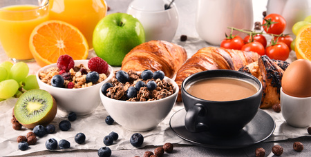 Breakfast served with coffee, orange juice, croissants, egg, cereals and fruits. Balanced diet.