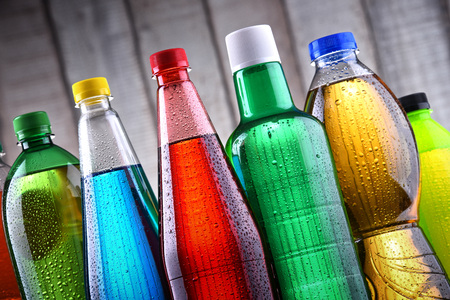 Plastic bottles of assorted carbonated soft drinks in variety of colors.の写真素材