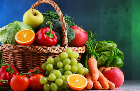 Fresh organic fruits and vegetables in wicker basket.の写真素材