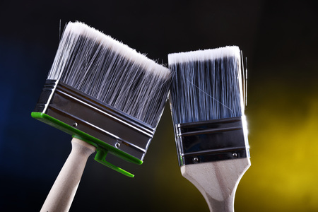 Two medium size paintbrushes for home decorating purposes.