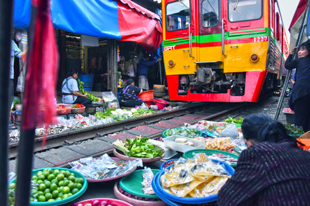 MAEKLONG, THAILAND - JAN 12, 2018: Train passing through Maeklong railway market, Thailandのeditorial素材