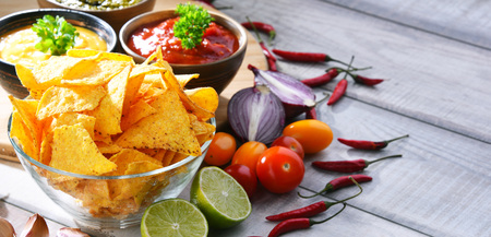 Composition with glass bowl of potato chips and dipping sauces.の写真素材