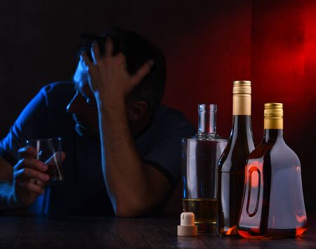 Bottles with alcoholic beverages and the figure of a drunk manの写真素材