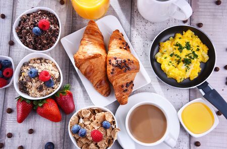 Breakfast served with coffee, orange juice, croissants, egg, cereals and fruits. Balanced diet.の写真素材