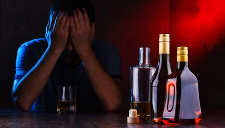 Bottles with alcoholic beverages and the figure of a drunk manの写真素材