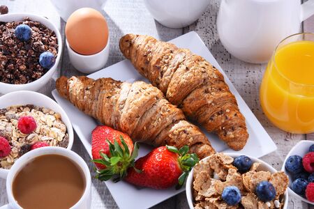 Breakfast served with coffee, orange juice, croissants, egg, cereals and fruits. Balanced diet.の写真素材