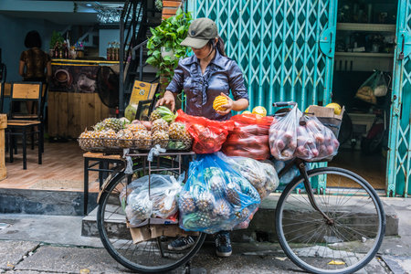 HANOI, VIETNAM - SEP 19, 2019: Vietnamese woman selling fruit on a bike in the old town of Hanoi, Vietnamのeditorial素材