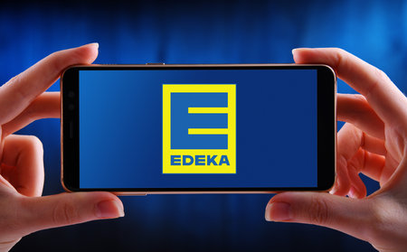 POZNAN, POL - MAY 21, 2020: Hands holding smartphone displaying logo of Edeka, the largest German...