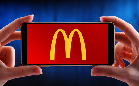 POZNAN, POL - JUN 20, 2020: Hands holding smartphone displaying logo of McDonald's, an American fast...